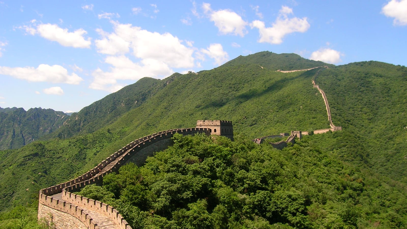 The Great Wall of China winding along forested ridges