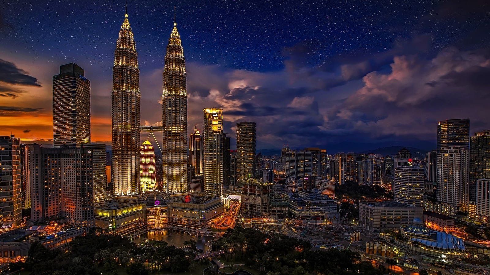 The Petronas Twin Towers lit at dusk above the Kuala Lumpur skyline, Malaysia